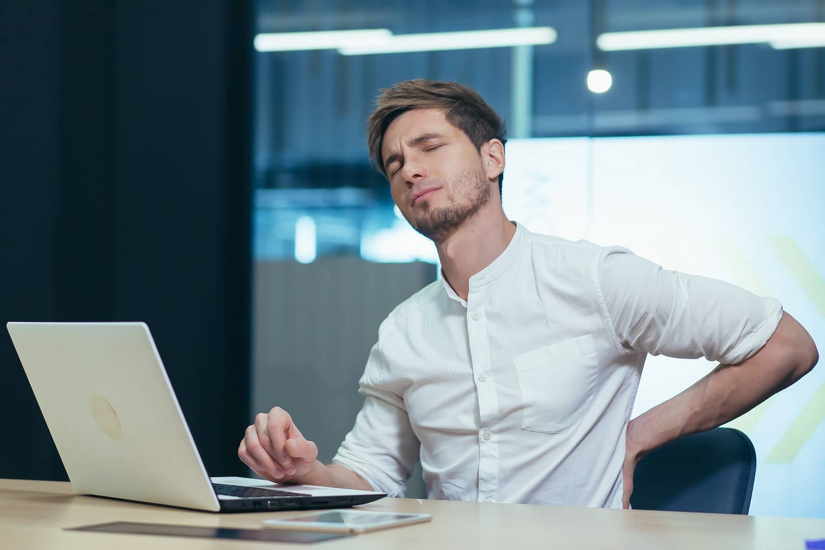 Young businessman working in the office, tired has back pain.